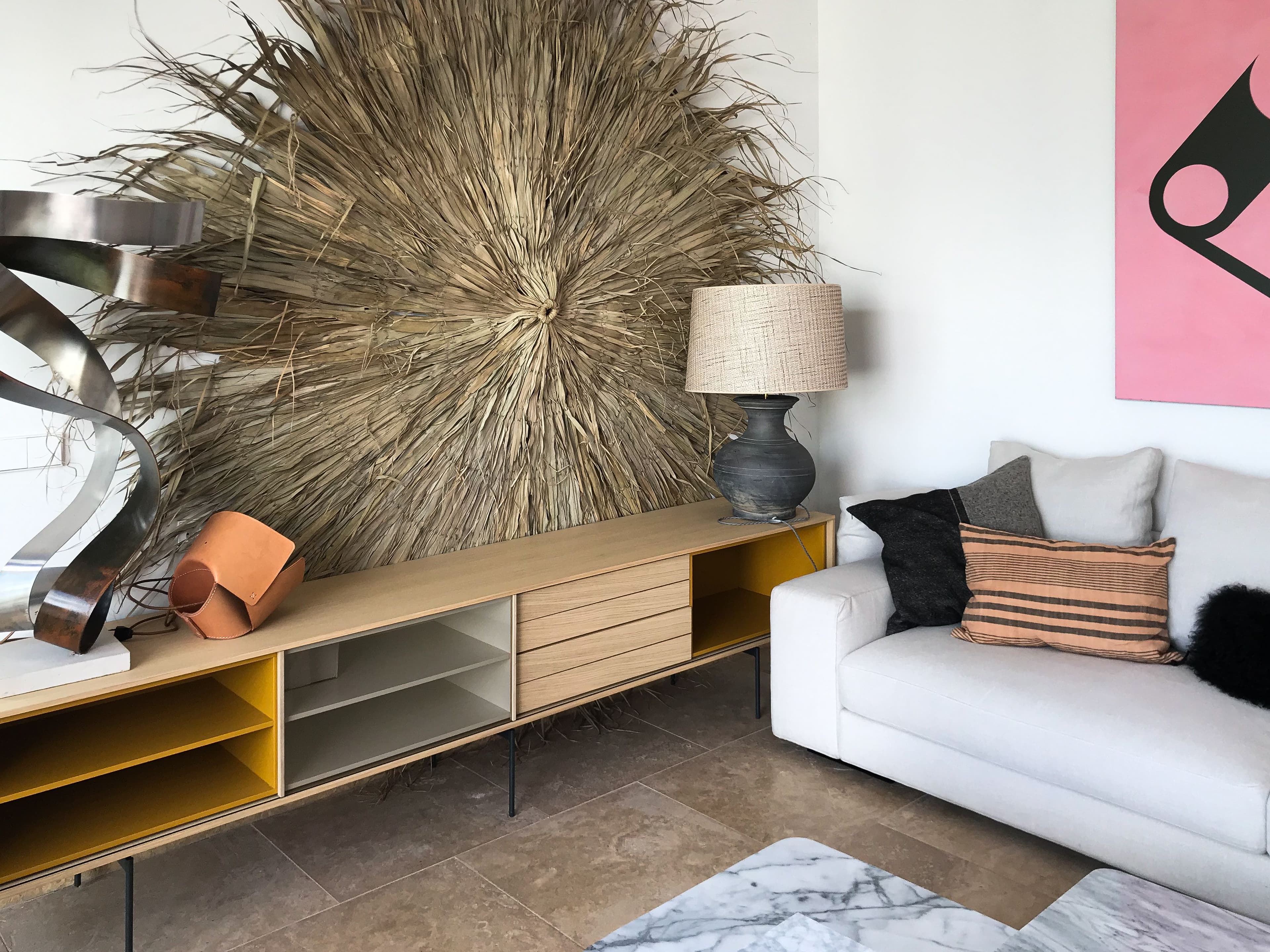 Gran sol de fibra vegetal sobre aparador de madera con módulos amarillos