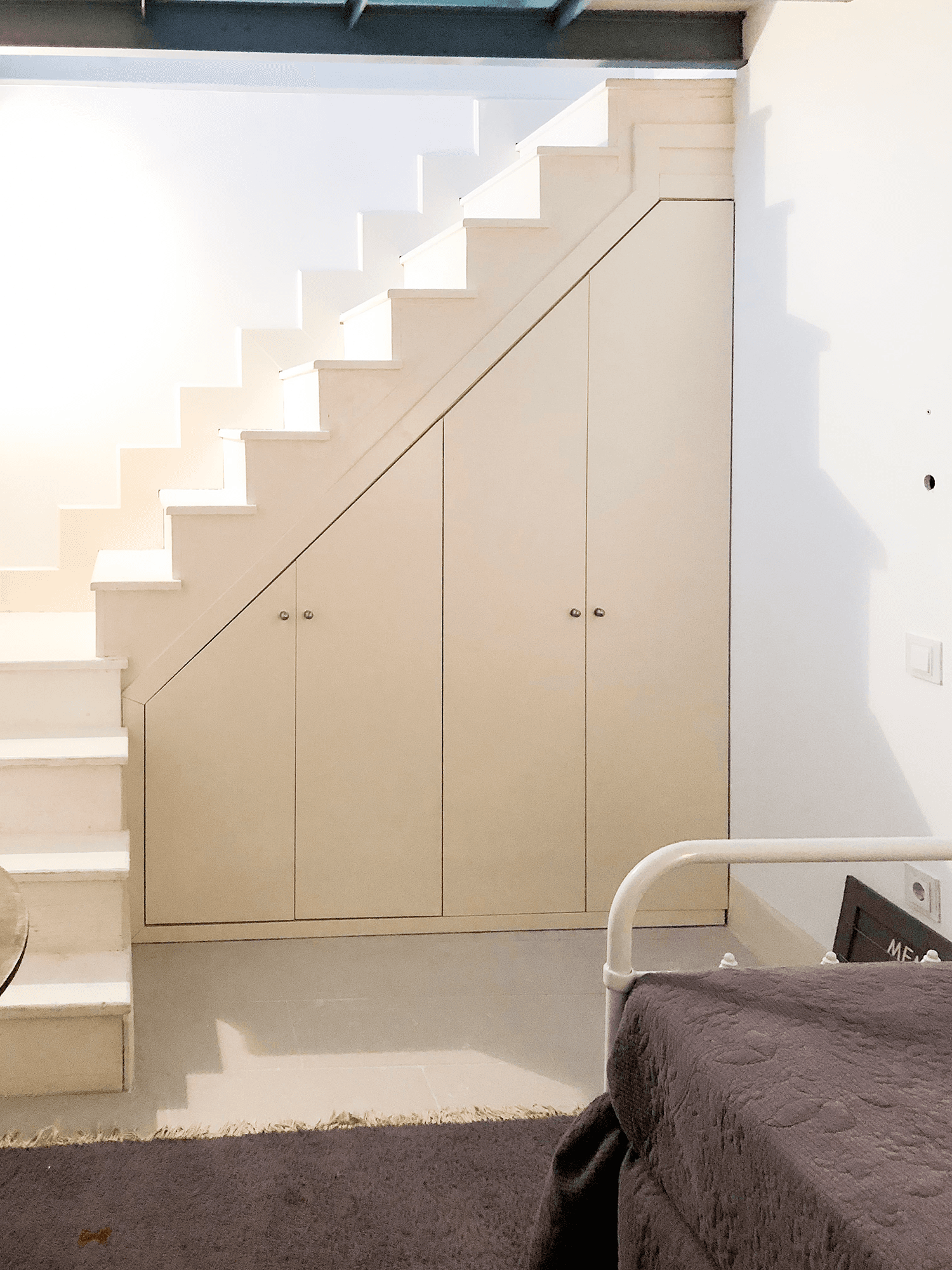 Escalera blanca con armarios integrados junto al dormitorio
