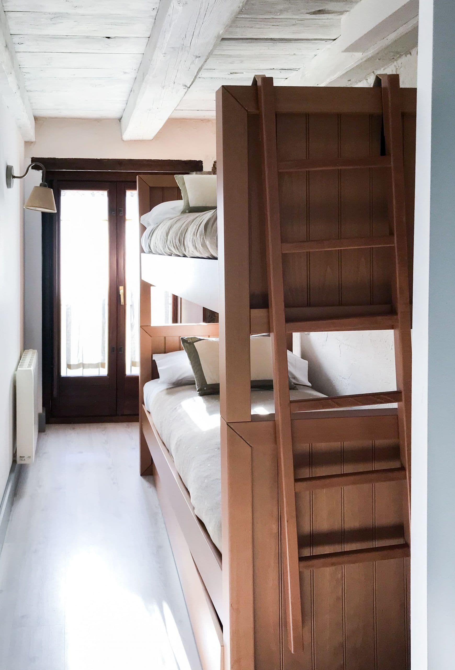 Literas de madera con escalera integrada junto al balcón