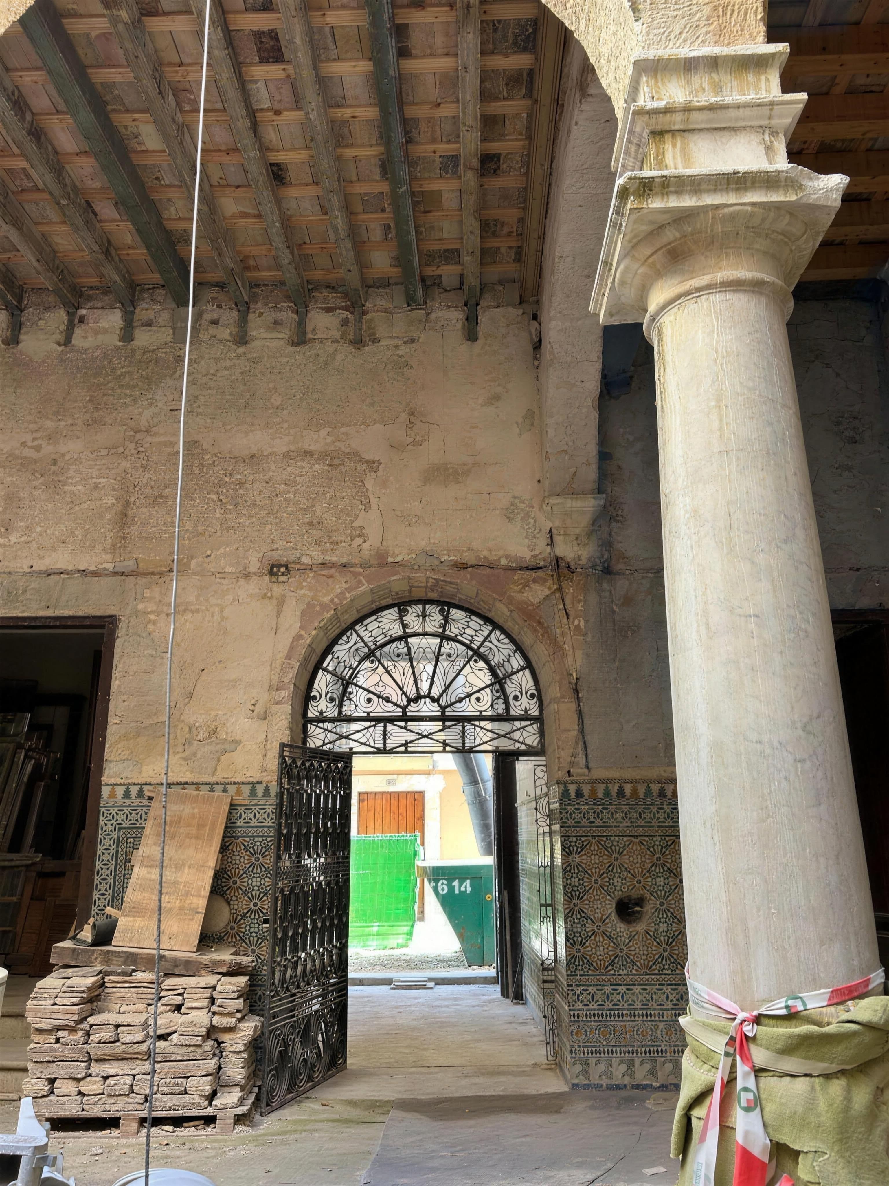 Columna toscana y techo de vigas del zaguán, con cancela de forja hacia la calle