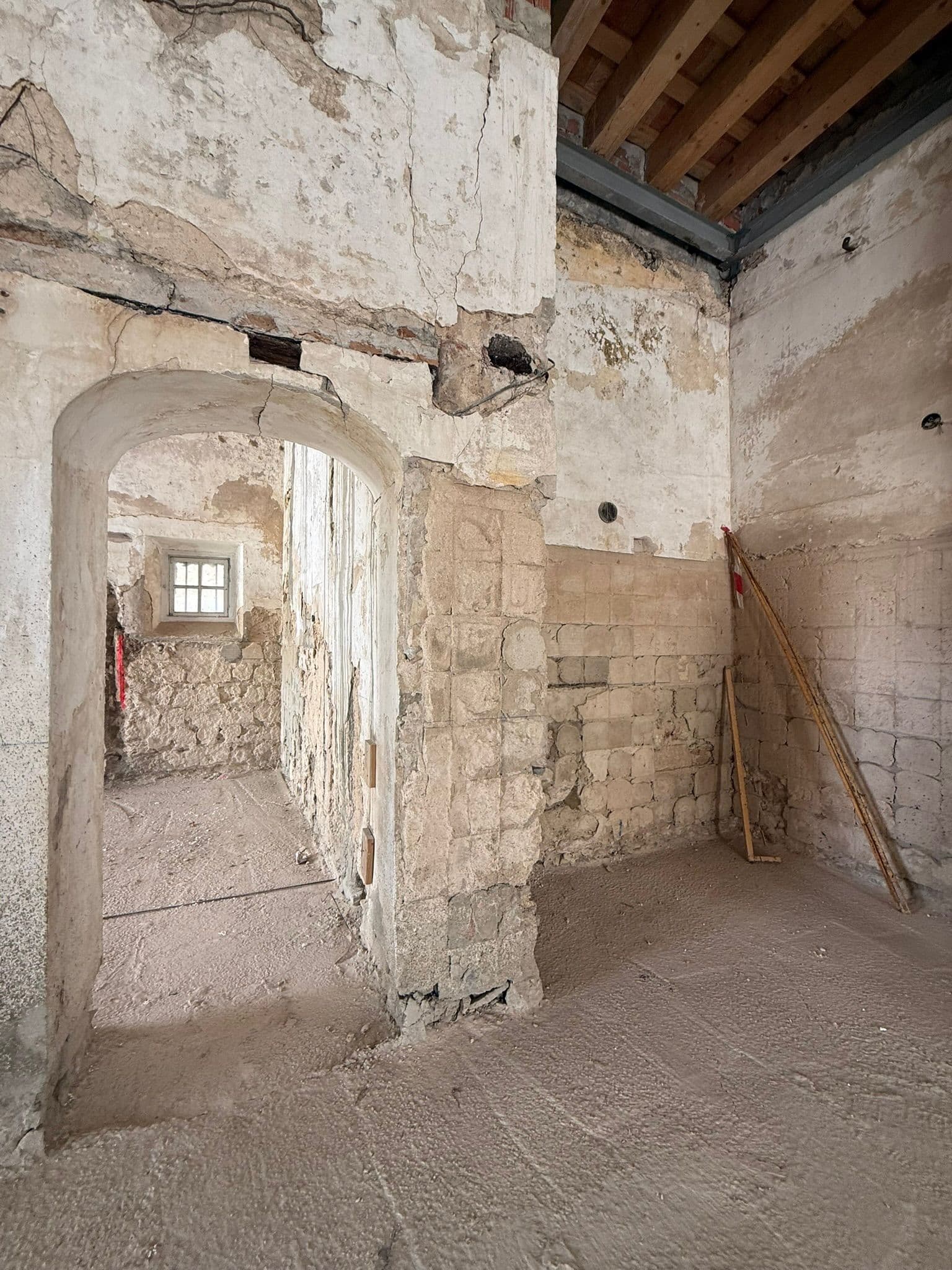 Esquina de muros centenarios: piedra, ladrillo y cal por capas