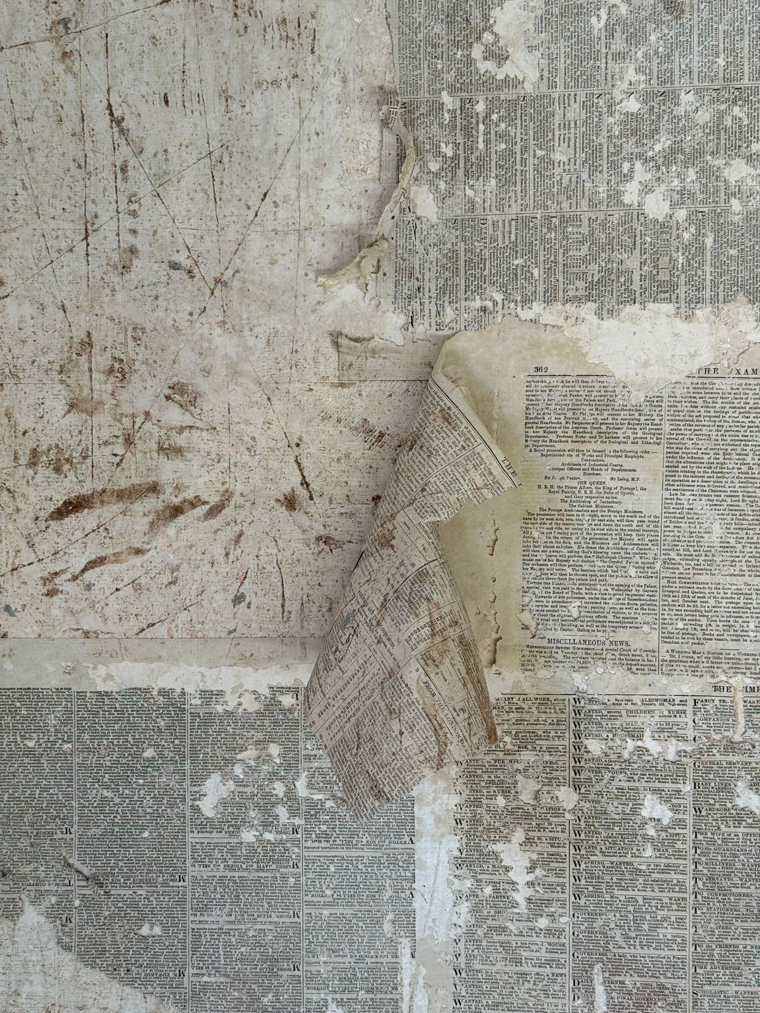 Capas de papel de periódico antiguo desprendiéndose del muro original