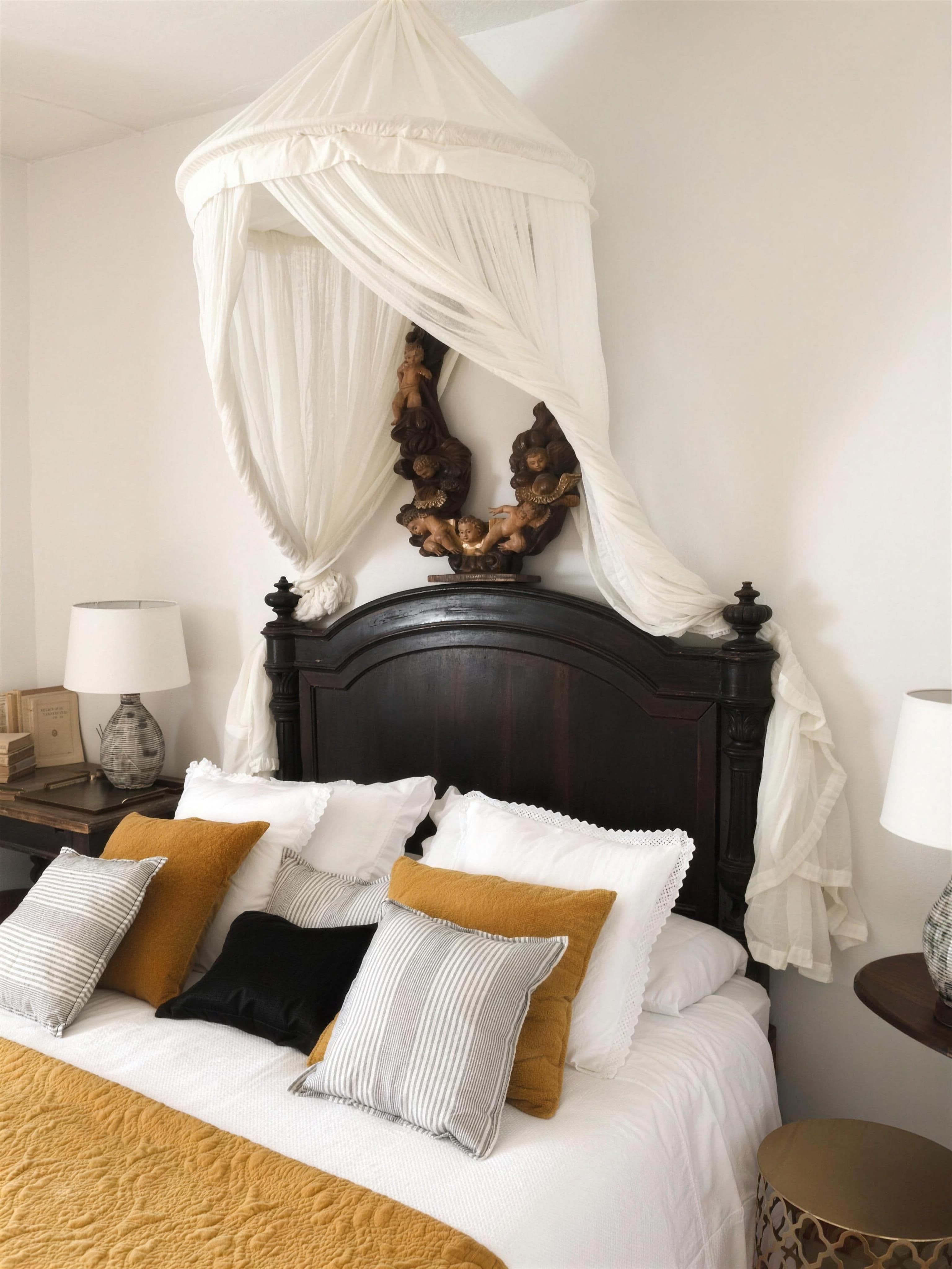 Cama con dosel de gasa blanca, cabecero antiguo tallado y cojines ocres